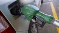 Green plastic fuel gun filling the gasoline tank