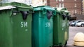 Green plastic garbage collection containers. In a row on the street Royalty Free Stock Photo