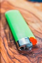 Green plastic gas lighter on olive wood background Royalty Free Stock Photo