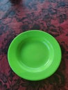 Green plastic plate on red flower table for chicken noodle bowl reason Royalty Free Stock Photo