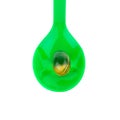 green plastic spoon.Capsules fish oil isolate on white backgrou