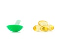 green plastic spoon.Capsules fish oil isolate on white backgrou