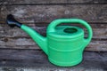 Green plastic sprinkling can outdoor in garden. Watering can