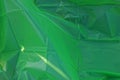 Green plastic texture of a piece of crumpled cellophane