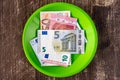 Green plate with Euro notes.