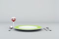 Green Plate with Glass of Red wine, fork, knife and spoon Royalty Free Stock Photo