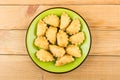 Green plate with small fried chebureks on wooden table Royalty Free Stock Photo