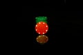 Green pocker chips stack with a red chip in front isolated on black with reflection Royalty Free Stock Photo