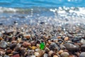 Green polished glass pebble on seashore