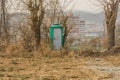 Green portable toilet with dirty white door