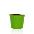 Green pot with handful soil for growing plant isolated on white background