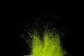 Green powder explosion on black background. Colored cloud. Colorful dust explode. Paint Holi.