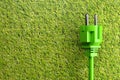 Green power cord with plug on grass background - eco or green power consumption concept, 3D illustration Royalty Free Stock Photo