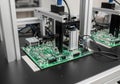 Green printed circuit board (PCB) is mounted on a lab table, connected with wires to a robotic Royalty Free Stock Photo