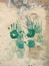 Green prints of children`s hands on the wall