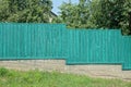 Green private wooden fence wall on gray concrete foundation Royalty Free Stock Photo