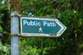 A green public walking path sign pointing to the right