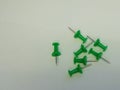 7 Green Push Pins on Grey Background