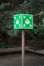 Green rallying sign in the middle of the image surrounded by vegetation.