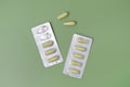 Green rectal pills or suppositories for anal or vaginal use with blister on green background. Medicines for alternative