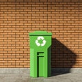 Green recycle bin near brick wall Royalty Free Stock Photo