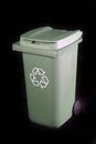 Green recycle rubbish or garbage bin with the recycle symbol on a black background Royalty Free Stock Photo