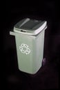 Green recycle rubbish or garbage bin with the recycle symbol on a black background Royalty Free Stock Photo