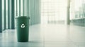 Green recycling bin stands in a bright, modern office space, symbolizing the company's commitment to environmental Royalty Free Stock Photo