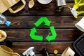 Recycling symbol and different garbage, paper bag, cup, flatware, plastic bottle for ecology wooden background top view Royalty Free Stock Photo