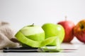 Green and red apple being prepared with knife and being peeled