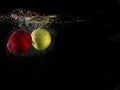 Green and red apple falling into splashing water on black background and copy space Royalty Free Stock Photo