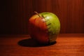 Green and red apple stapled with two halves Royalty Free Stock Photo