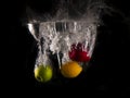 Green and red apple , yellow lemon falling into splashing water on black background Royalty Free Stock Photo