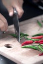 Green and red chilie peppers being cut on a wooden board Royalty Free Stock Photo