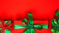 Green and red gift box with ribbon and bow on red background. Flat lay. Top view. Copy space. Happy Christmas, New year, Birthday Royalty Free Stock Photo