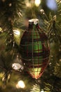 Green, red, and gold plaid tulip Christmas ornament hanging on tree Royalty Free Stock Photo