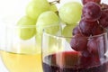 Green and red grapes on the white and red wine glasses Royalty Free Stock Photo