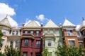 Green, red, and orange row houses in Washington DC on a summer day.