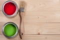 Green and red paint in the bank with brush on the light wooden background with copy space for your text. Top view Royalty Free Stock Photo