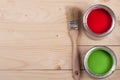 Green and red paint in the bank with brush on the light wooden background with copy space for your text. Top view Royalty Free Stock Photo