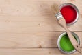 Green and red paint in the bank with brush on the light wooden background with copy space for your text. Top view Royalty Free Stock Photo