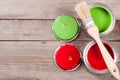 Green and red paint in the bank with brush on the old wooden background with copy space for your text. Top view Royalty Free Stock Photo