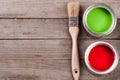 Green and red paint in the bank with brush on the old wooden background with copy space for your text. Top view Royalty Free Stock Photo