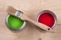 Green and red paint in the bank to repair and brush on the light wooden background Royalty Free Stock Photo