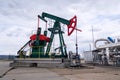 Green and red pumpjack, oil horse, oil derrick pumping oil well with dramatic cloudy sky background Royalty Free Stock Photo
