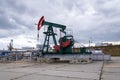 Green and red pumpjack, oil horse, oil derrick pumping oil well with dramatic cloudy sky background Royalty Free Stock Photo