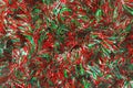 Green and red shiny Christmas tinsel close up. Christmas background with garland and copy space Royalty Free Stock Photo