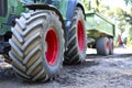 Green and red tractor with big wheels and selective focus. Tractor on a construction area