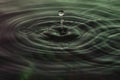 Green and red water dropping, water ripples in a pond. waves of rippling water Royalty Free Stock Photo