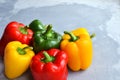 Green, red and yellow bell pepper on grey stone background. Organic healthy food. Copy space Royalty Free Stock Photo